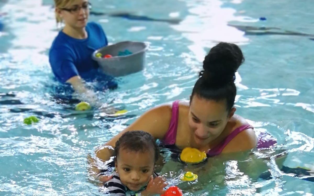 Mother and child in pool with instructor