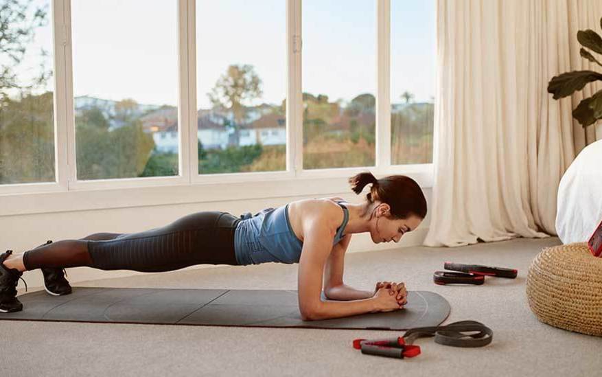 Female in plank position on workout mat at home